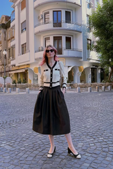 a lady in a cardigan and a black skirt